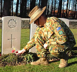 Australian serviceman laying a spray of poppies on 11 November.