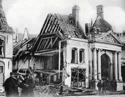 Damage caused to the historic buildings in Ypres from April 1915. Two French soldiers are in the foreground of the picture.