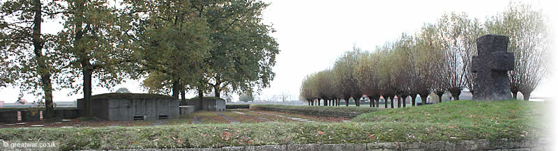 The basalt-lava cross on the roof of a bunker in the north-east corner of the cemetery. The view is looking north-west into the rear of two original German battlefield bunkers. The basalt-lava cross on the roof of a bunker in the north-east corner of the cemetery. The view is looking north-west into the rear of two original German battlefield bunkers.