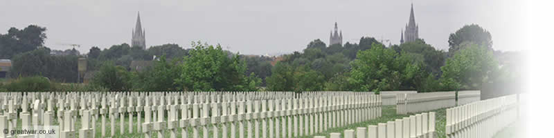 French military graves at Saint Charles de Potyze cemetery on the Ypres Salient battlefields. The spires of Ypres- Ieper are seen in the background.
