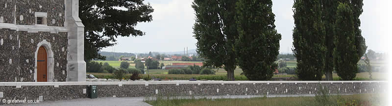Leaving the Visitors Centre visitors turn right to walk along the boundary wall of the cemetery, looking across the northern Ypres Salient towards the brickworks' chimneys at Zonnebeke, Ypres beyond them and the Kemmelberg hill on the far horizon.